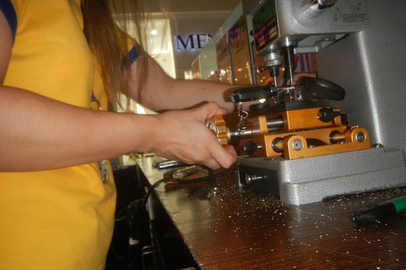 Hands guiding a key blank through a key cutting machine
